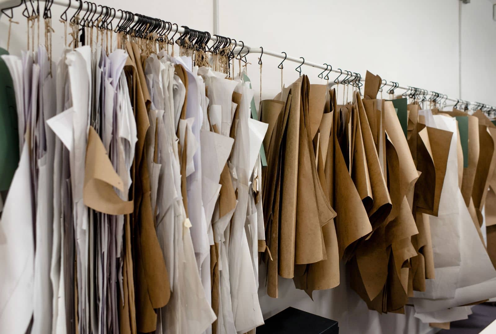 an assortment of beige-colored materials hanging on a rail